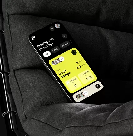 Smartphone on dark fabric showing UI/UX design learning app with bright yellow interface displaying course modules, user stats, and progress metrics